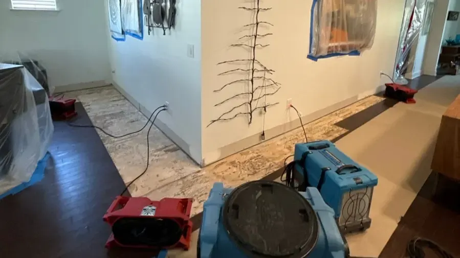 Air movers and a dehumidifier drying a Gallatin hallway with the flooring pulled up