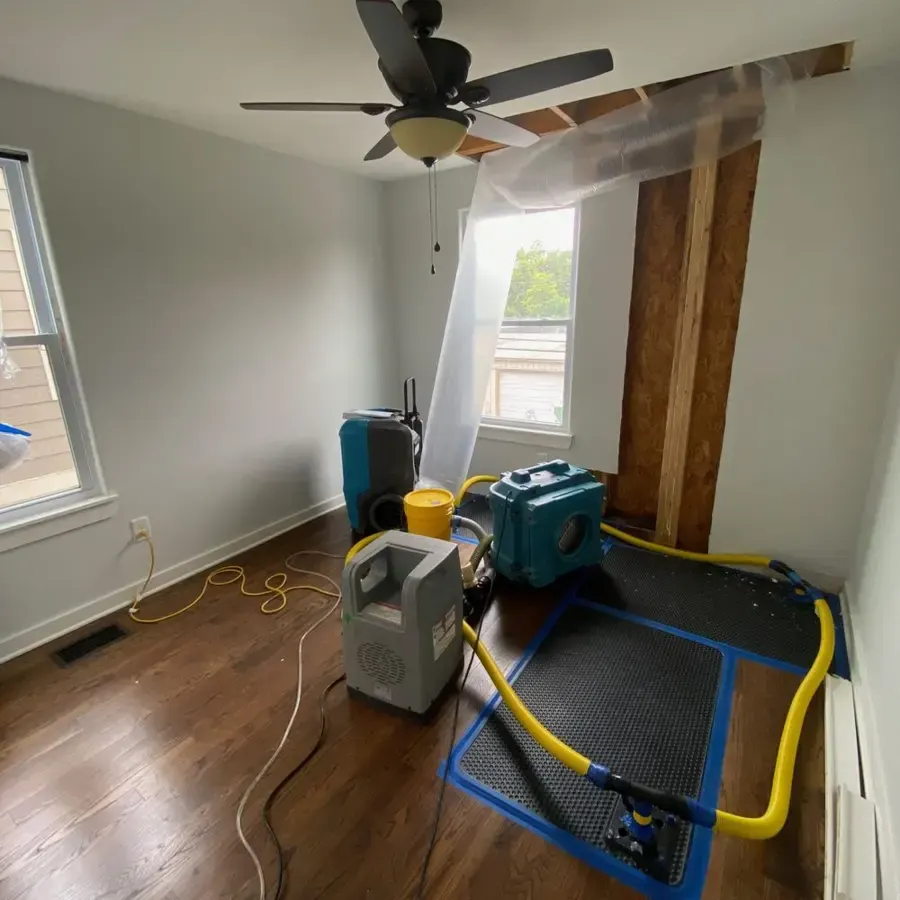 Hardwood floor drying mat system and a dehumidifier running in a bedroom